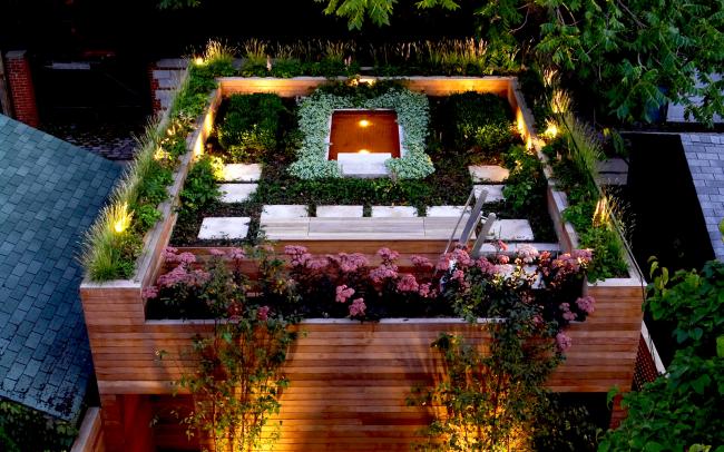 Illuminated roof garden with a pond at night