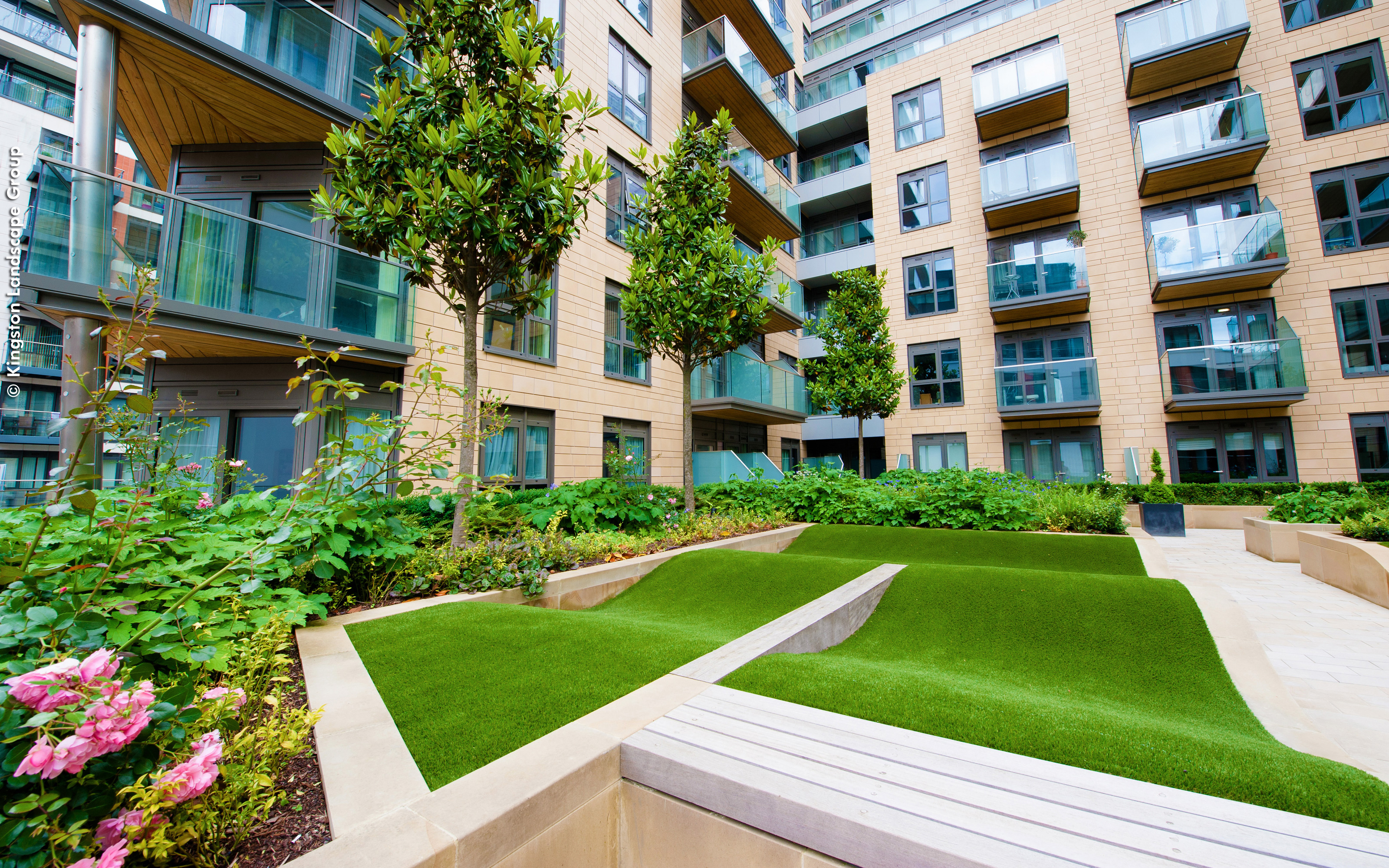 Courtyard with rolling mounds made from grass surrounded by residential blocks