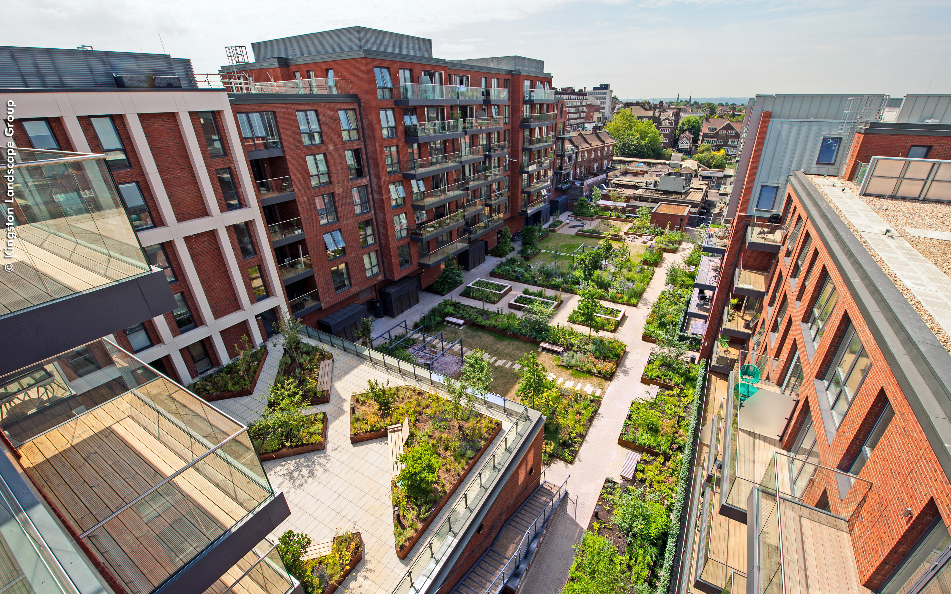 Bird's eye view onto the green courtyard surrounded by multi-storey buildings