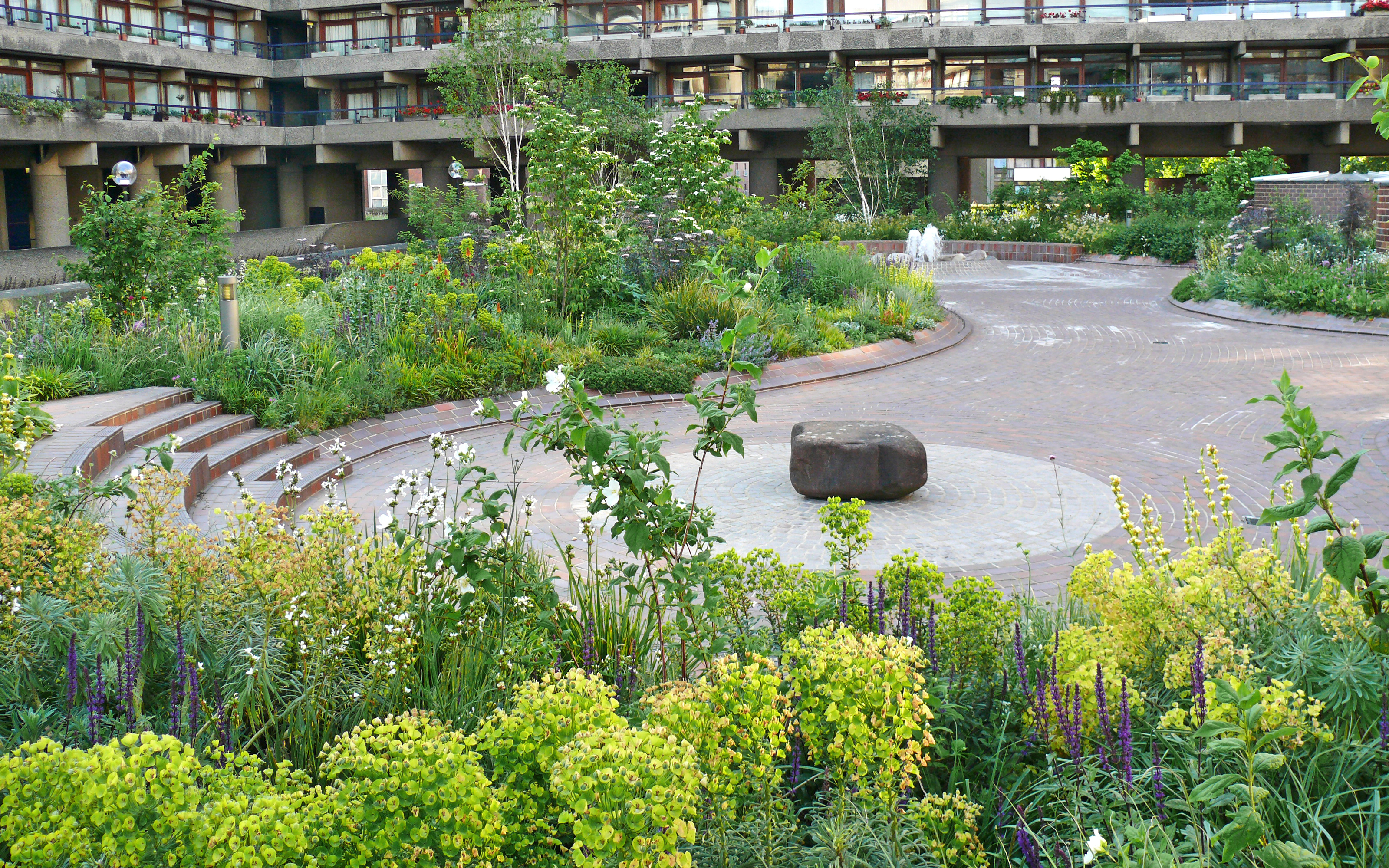 Plant beds with flowers and water feature surrounded by residential bocks