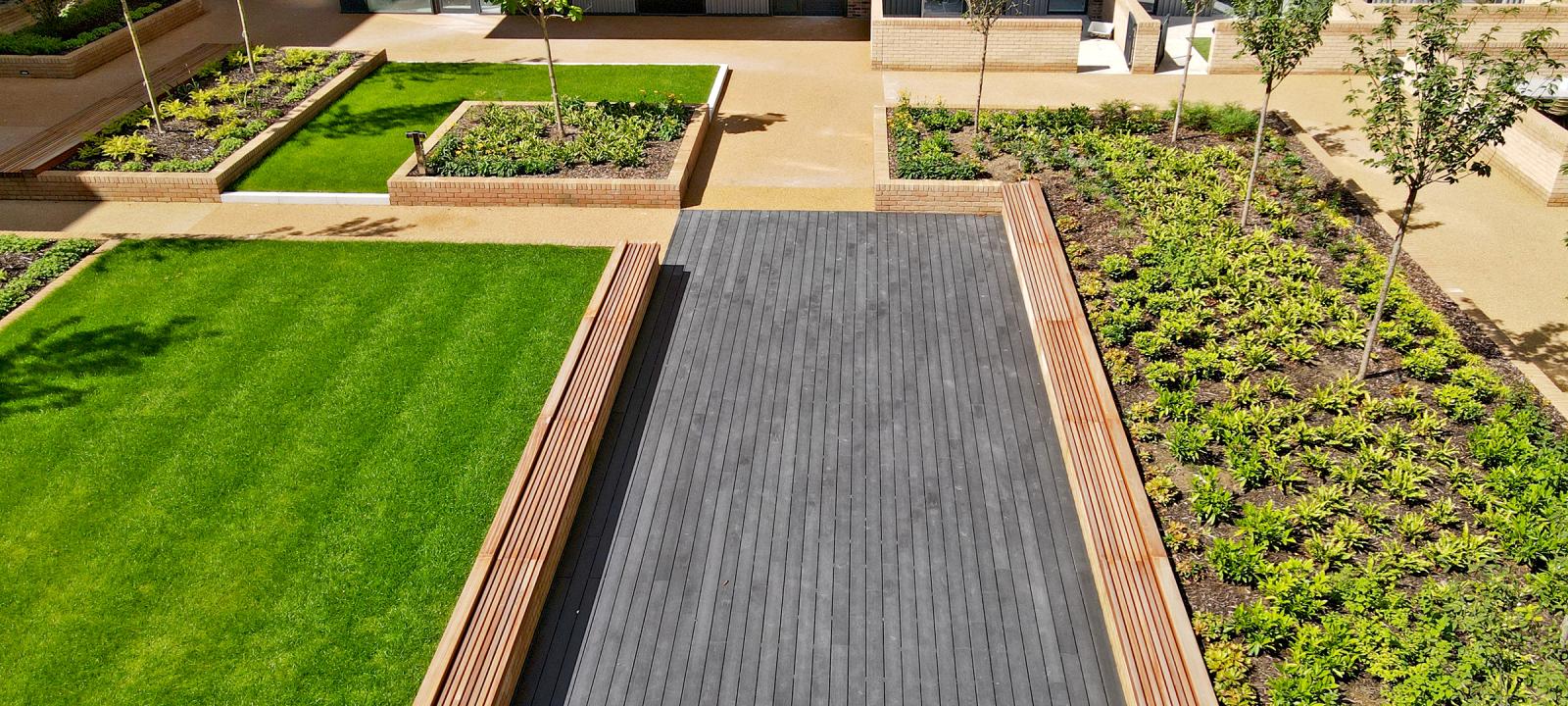 Courtyard with a podium deck, lawn, wooden benches and small trees