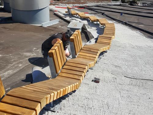 Wooden benches being constructed on a pitched roof