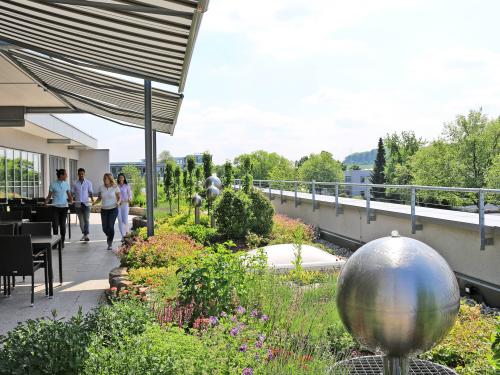People on a roof garden with water feature and sitting area