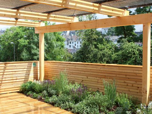 Roof garden with wooden deck and PV pergola