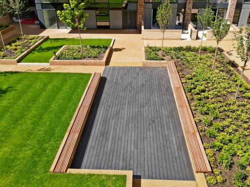 Courtyard with a podium deck, lawn, wooden benches and small trees