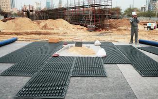 Worker laying out Stabilodrain® mats on the building site 