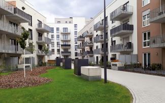 The special herringbone pattern prevents the paving from moving when cars or refuse vehicles are driving on it. Lawn, small trees and driveways surrounded by housing blocks