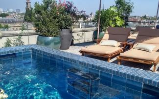 Any type of design is possible on a “Stormwater Management Roof“ – planters, walkways and even this pool. © ZinCo Benelux B.V. Swimming pool and deck chairs on a roof terrace