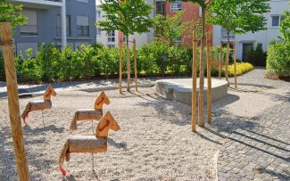 Playground with little wooden horses and trees