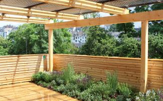 Roof garden with wooden deck and PV pergola