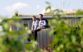 Two persons sitting on a green roof